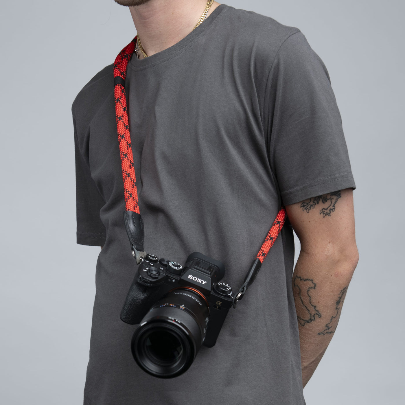 Leica camera on a photographer's hip held with red Double Rope Strap 