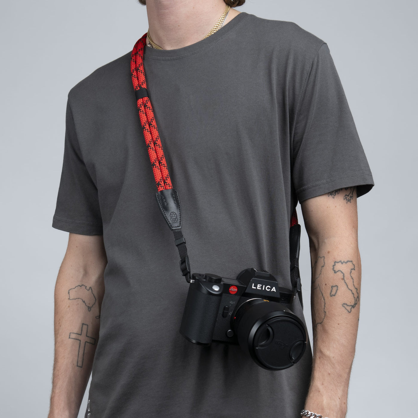 Leica camera on a photographer's hip held with red double rope strap 