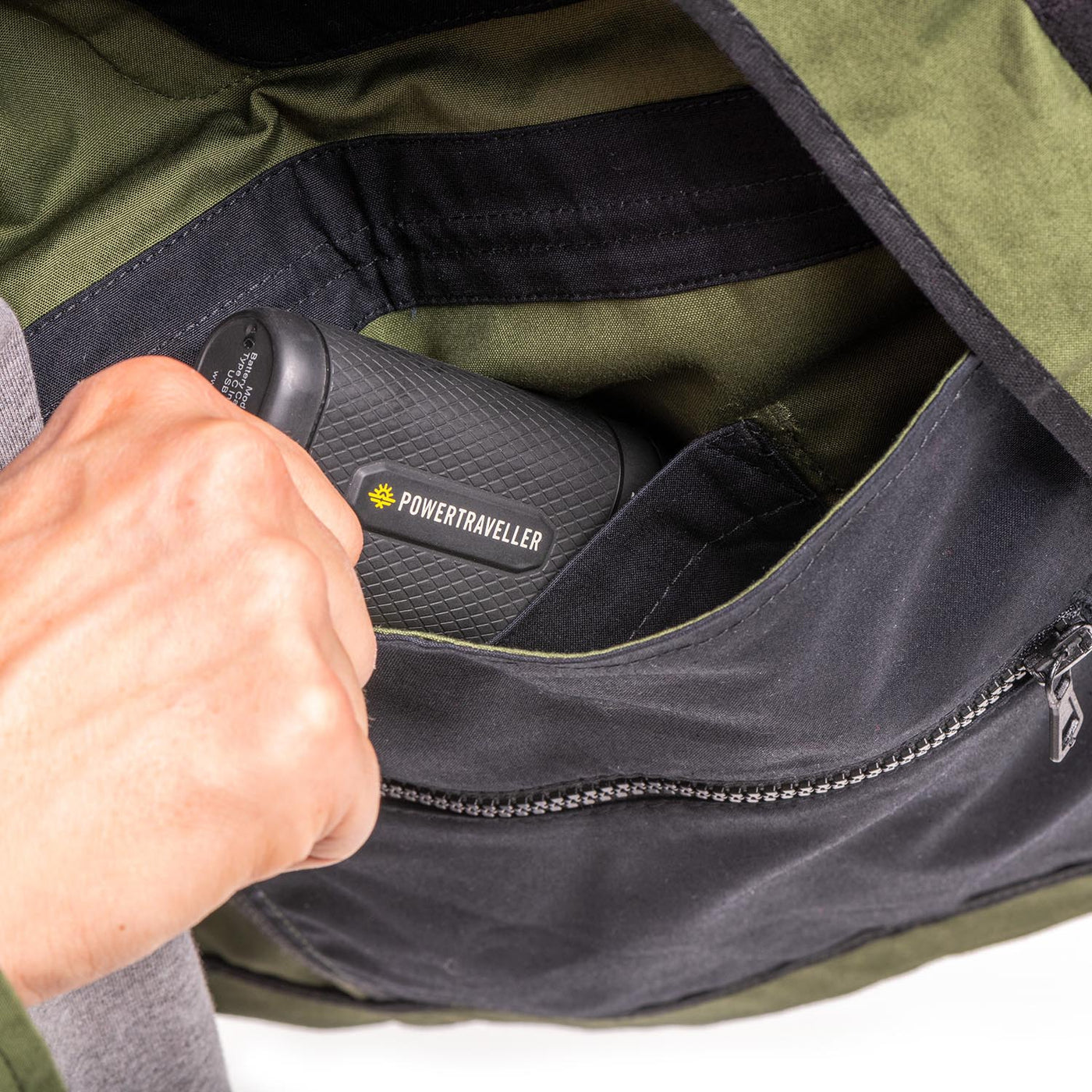 Closeup of the inside pockets of the jacket with photographer removing a powerbank 
