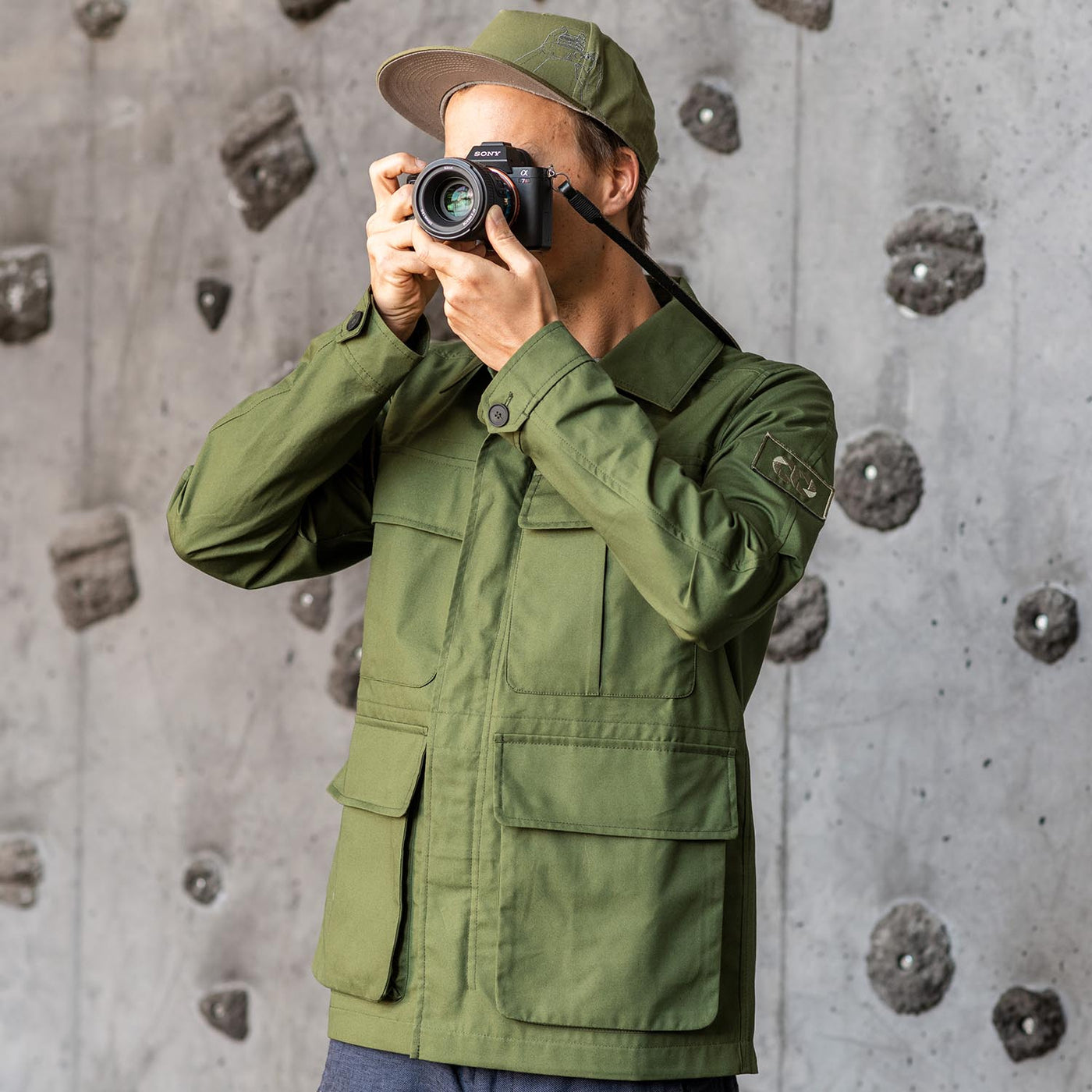 Photographer using a Sony camera wearing a olive field jacket 