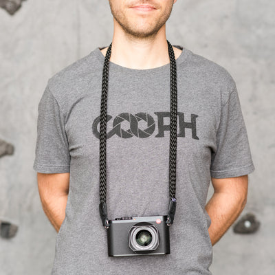Photographer wearing leica camera around the neck with braid strap 