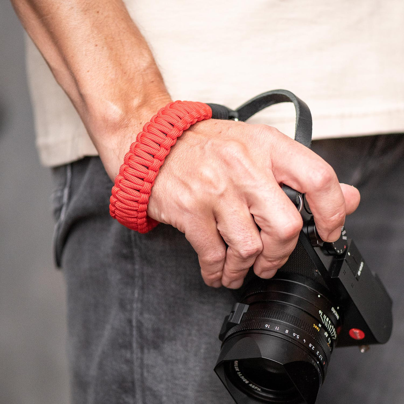 Red Leica Paracord Hand Strap around a photographer's wrist 