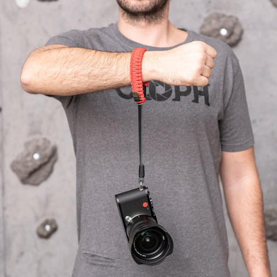 Red Leica Paracord Hand Strap around a photographer's wrist 