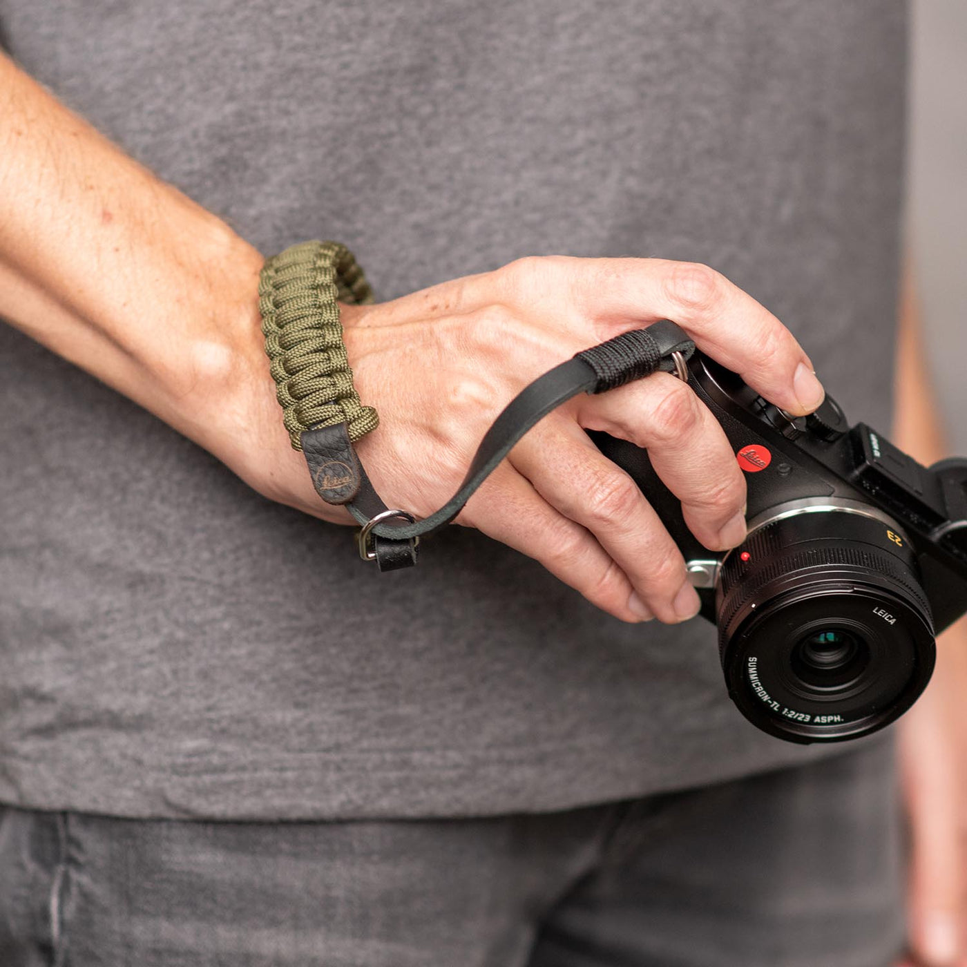 Olive Leica Paracord Hand Strap around a photographer's wrist 