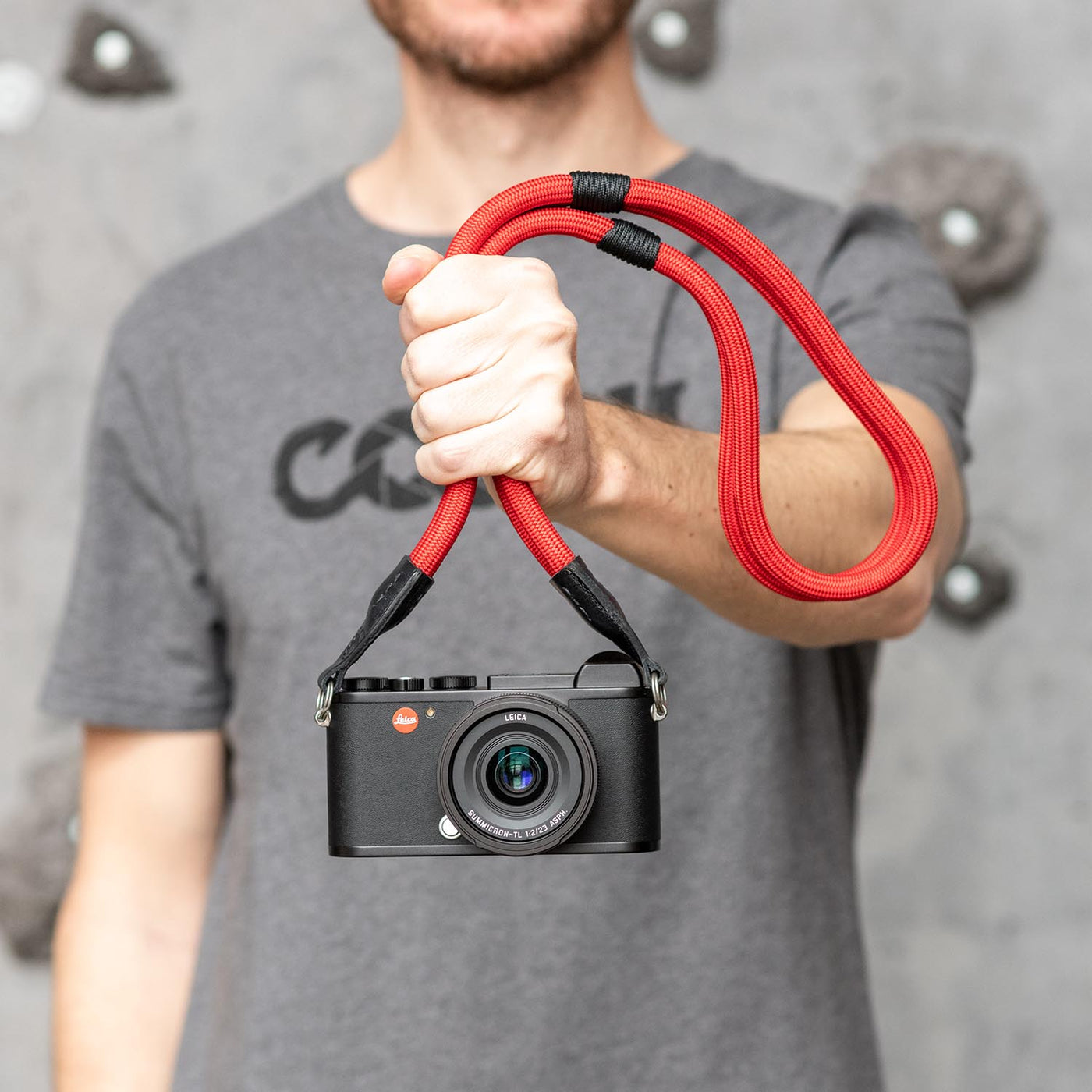 Photographer holding a Leica camera by the  Double Rope Strap 
