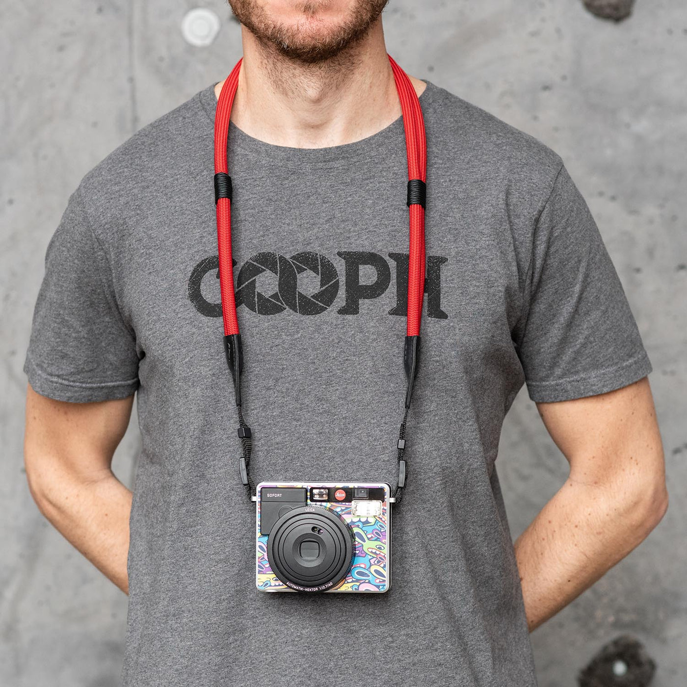 Photographer wearing leica camera around the neck with double rope strap 