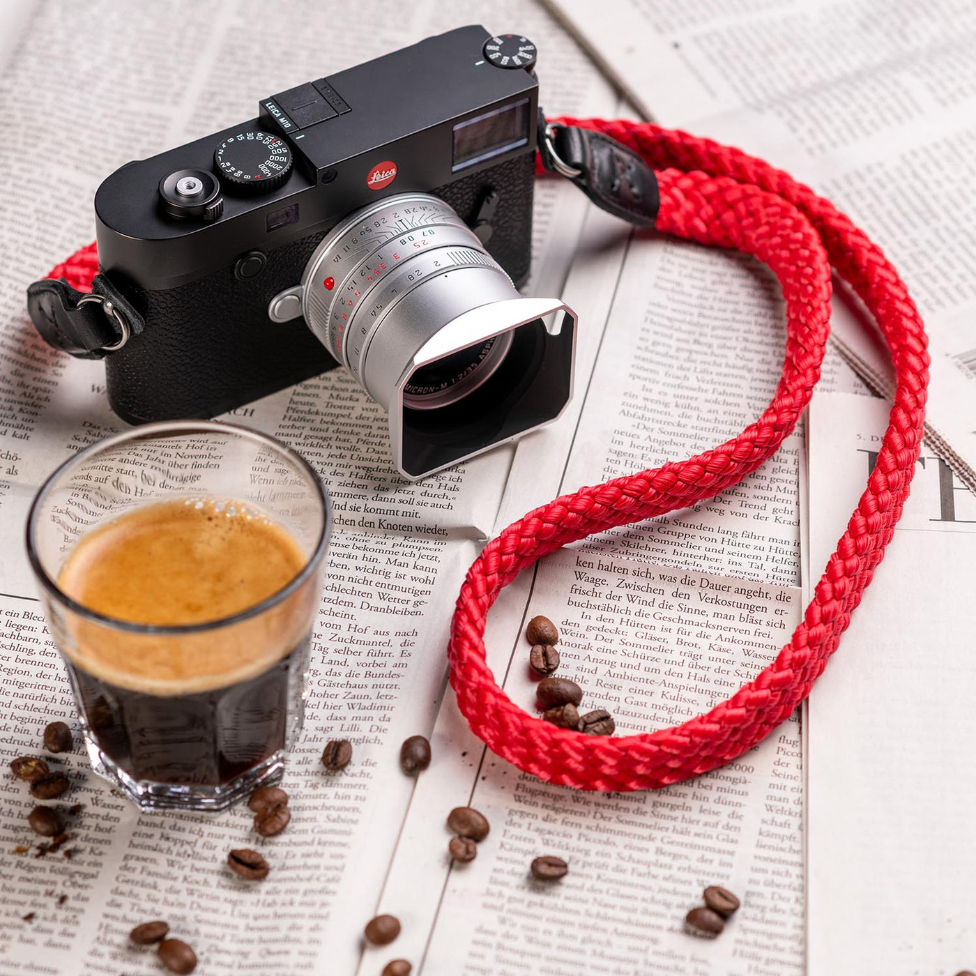 Leica Camera on table with coffee, coffee beans and Braid Camera Strap 