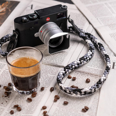 Leica Camera on table with coffee, coffee beans and Braid Camera Strap 