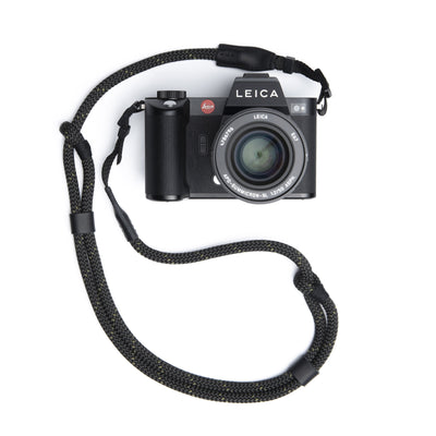 Black Leica Camera with lens with an Adjustable Rope Strap attached with webbing bads  