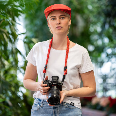 Female photographer holding Sony Camera with Adjustable Rope Strap around her neck 