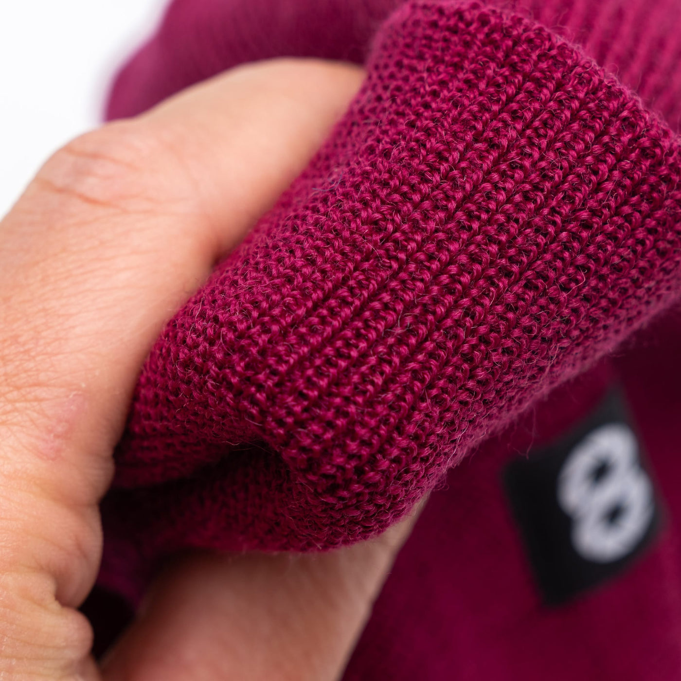 Close-up of edc beanie fabric in berry colour-way 