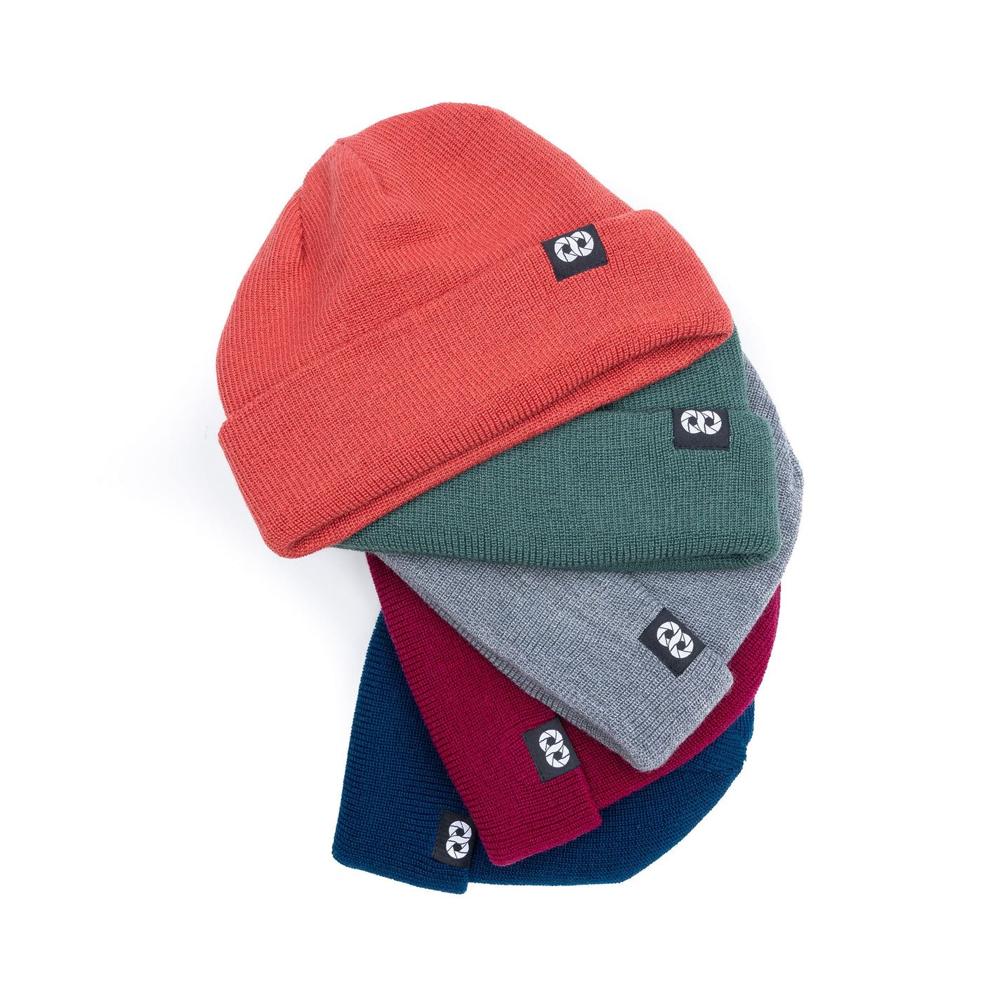 Stack of red, green, gray, and blue beanies with a brand logo on a white background 