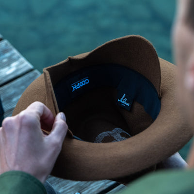 Photographer wearing the Cooph Tempest Hat by Mühlbauer in the gold colorway. 