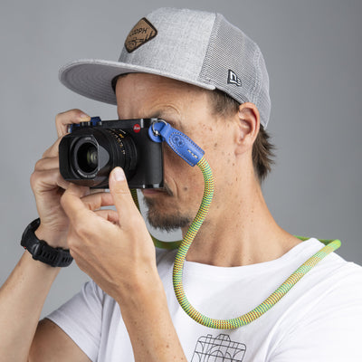 Photographer using Leica camera with Beers and camera rope strap 