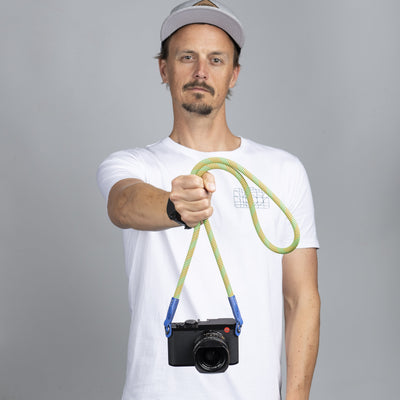 Photographer in a white t-shirt wearing a Leica camera around his neck with a Beers and Camera rope strap 