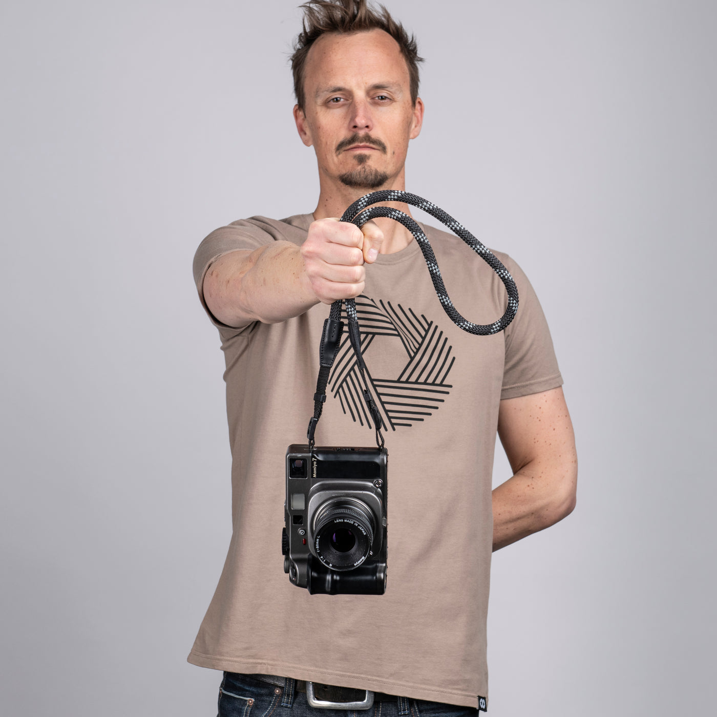 Photographer holding a camera by the strap 