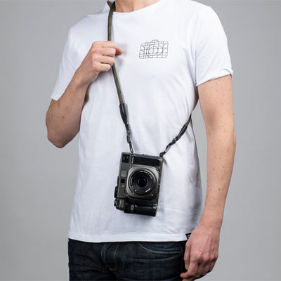 Leica camera on a photographer's hip held with olive rope strap 