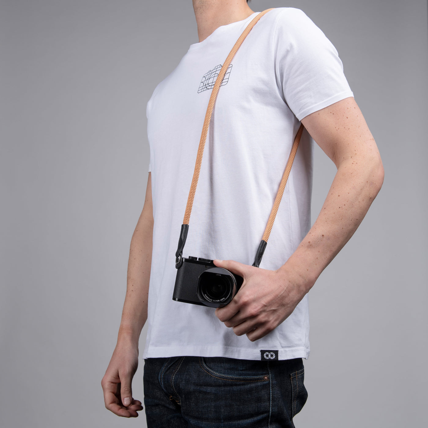Photographer wearing peach rope strap around shoulder with Leica camera 