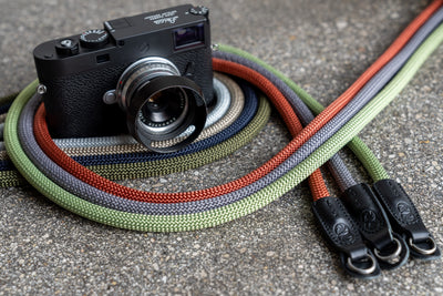 Multiple Cooph Rope Camera Straps around a Leica camera on a concrete floor