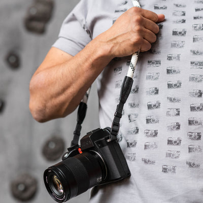 Leica camera on a photographer's hip held with white rope strap 