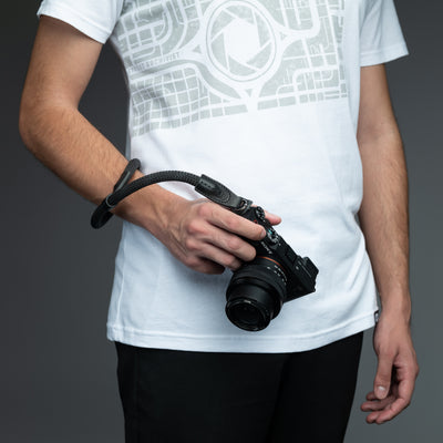 Photographer holding a camera attached to the wrist by the Rope Hand Strap 