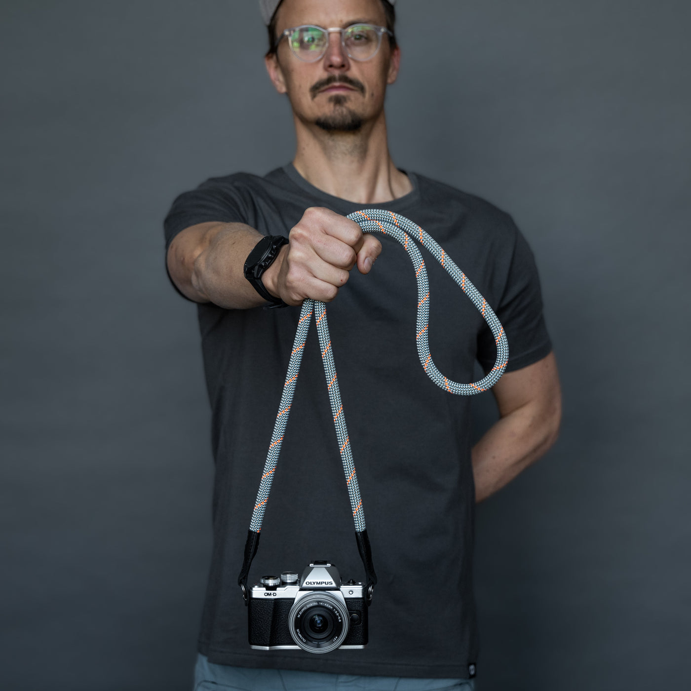 Photographer holding a Olympus camera by the Rope Camera Strap 