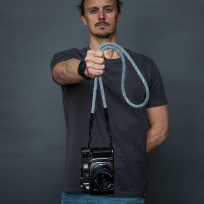Photographer holding a camera by the strap 