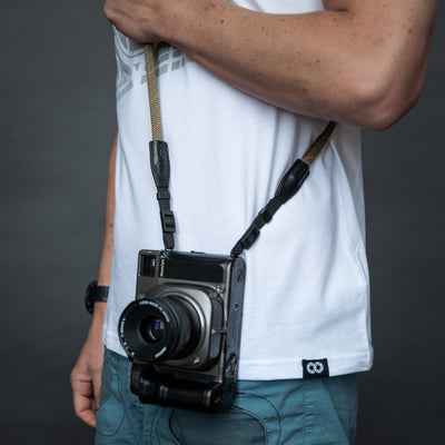 Retro camera on a photographer's hip held with rope strap 