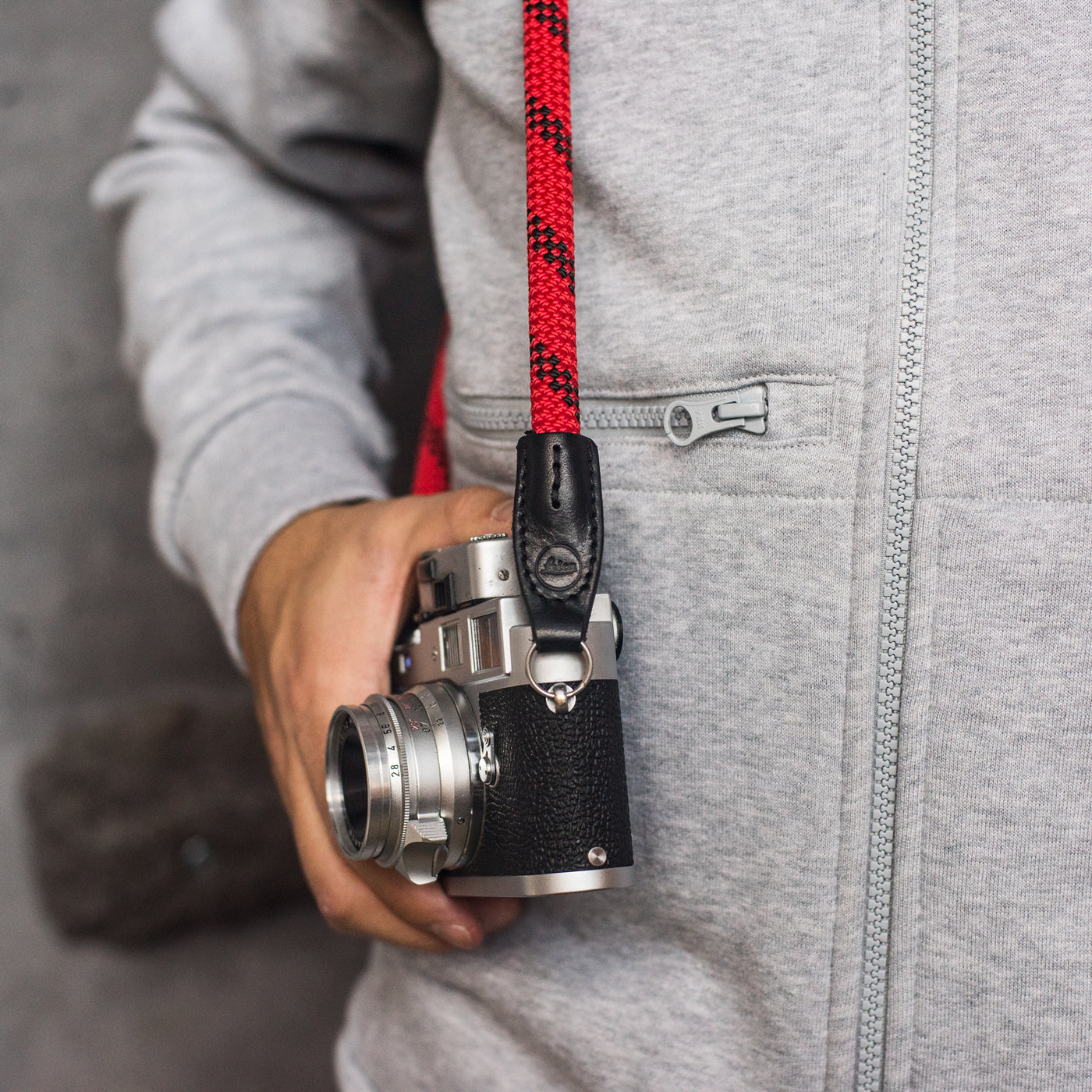 Camera on a photographer's hip held with rope strap 