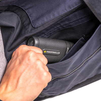 Closeup of the inside pockets of the jacket with photographer removing a powerbank 
