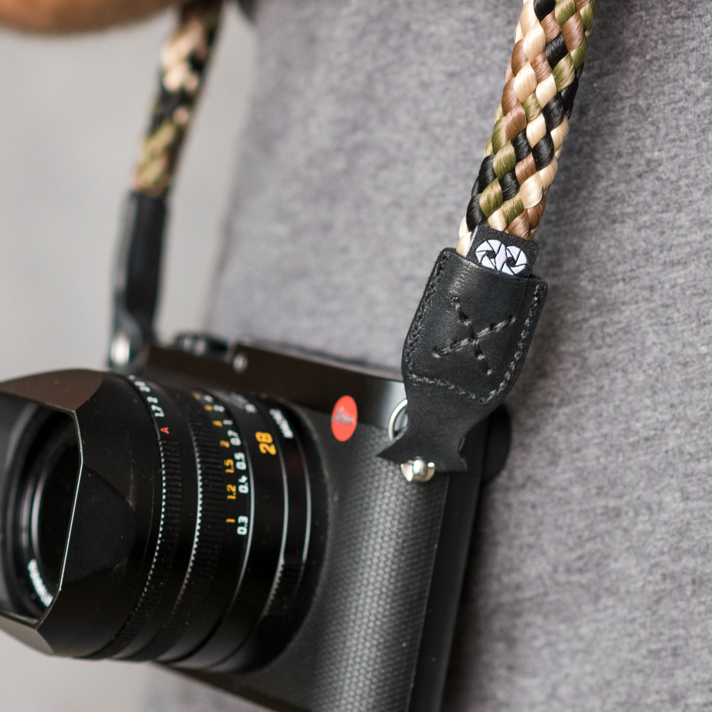 Leica camera on a photographer's hip held with braid camera strap 
