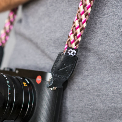 Leica camera on a photographer's hip held with braid camera strap  