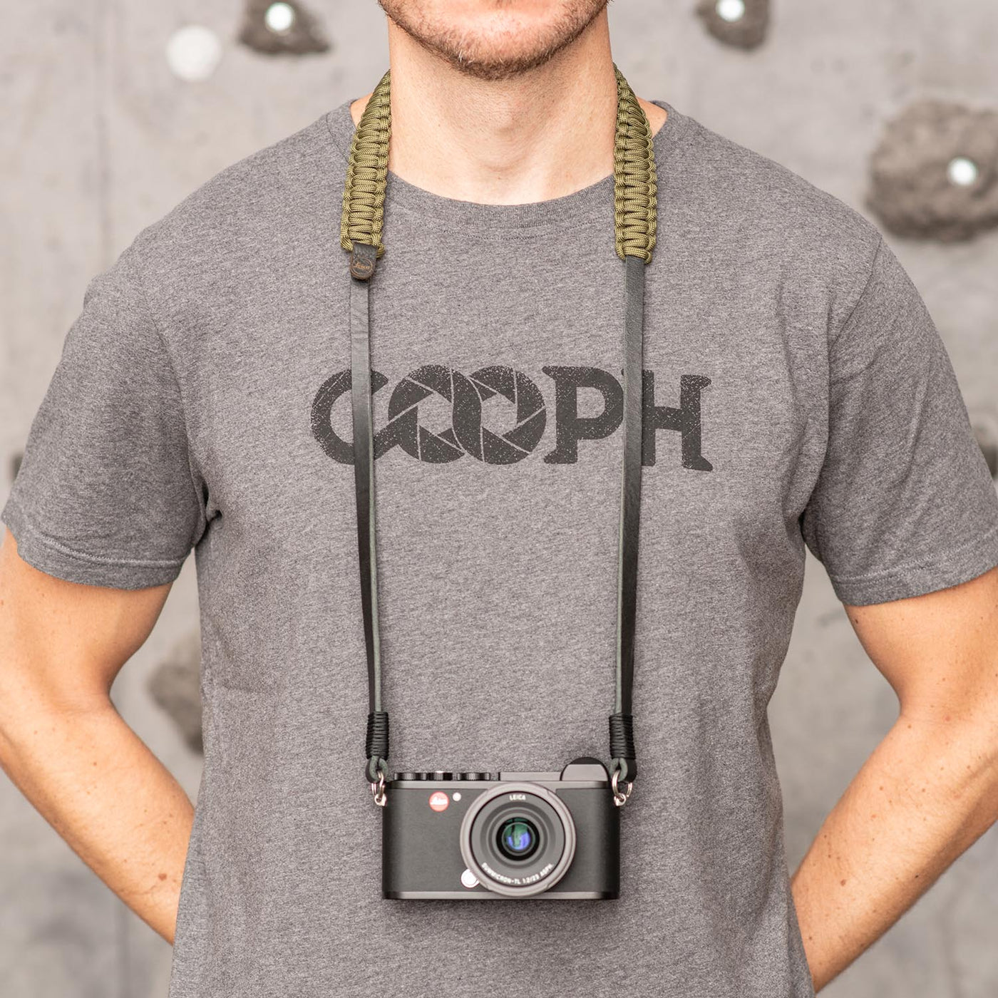 Photographer wearing leica camera around the neck with paracord strap 