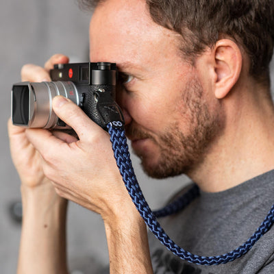 Photographer using Leica camera with braid strap 