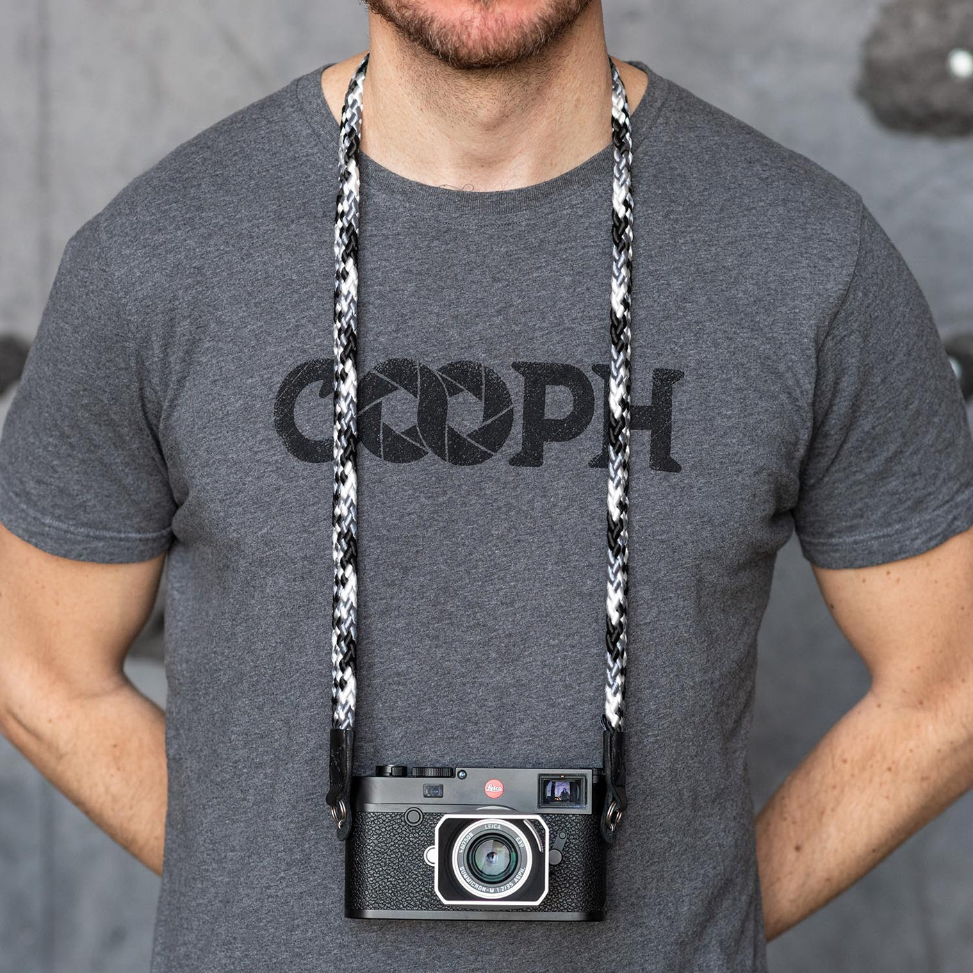Photographer wearing leica camera around the neck with braid strap 