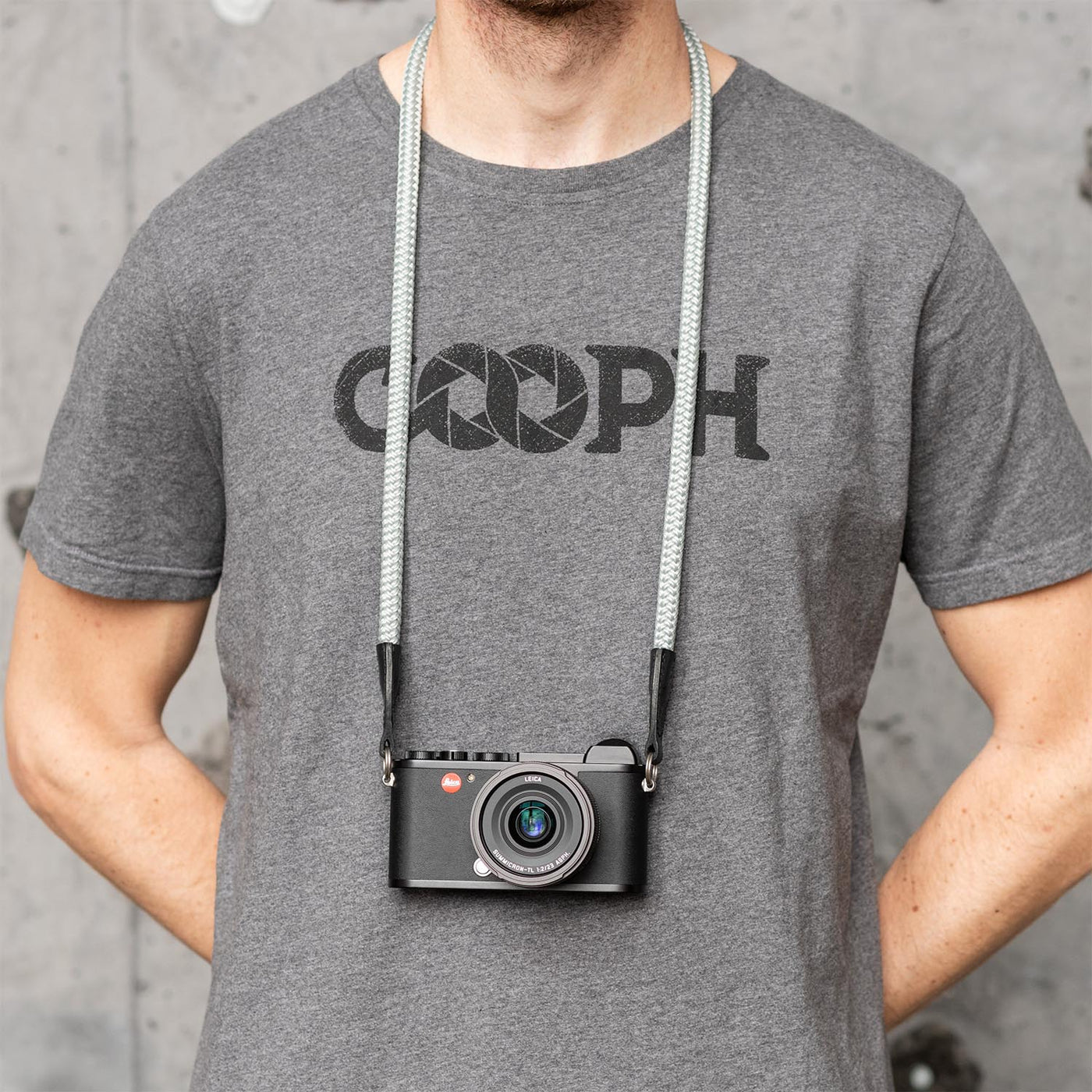 Photographer wearing leica camera around the neck with rope strap 