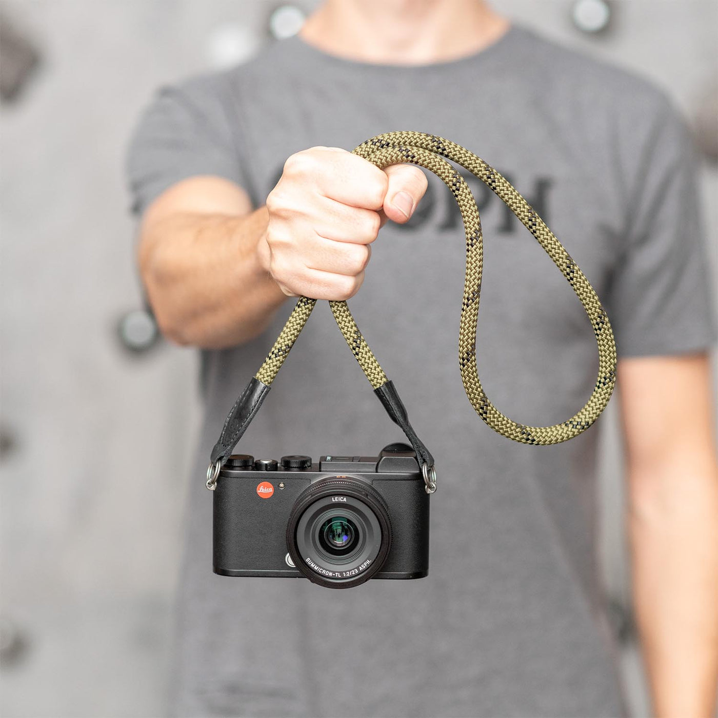 Photographer holding a Leica camera by the strap 